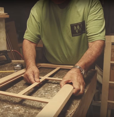 Woodmont Cabinetry technician assembles window pane frames to cabinet door